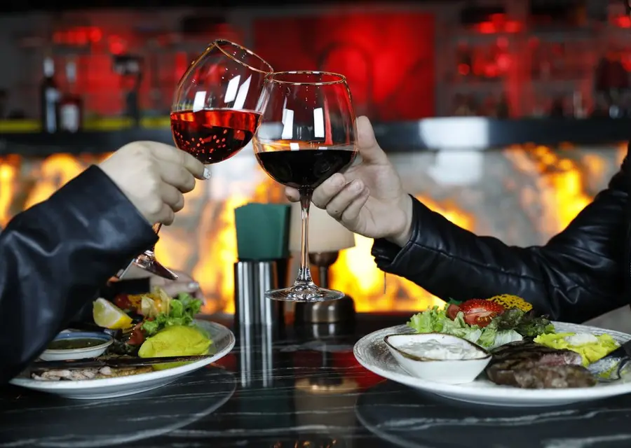 Casal brindando com taças de vinho durante o jantar