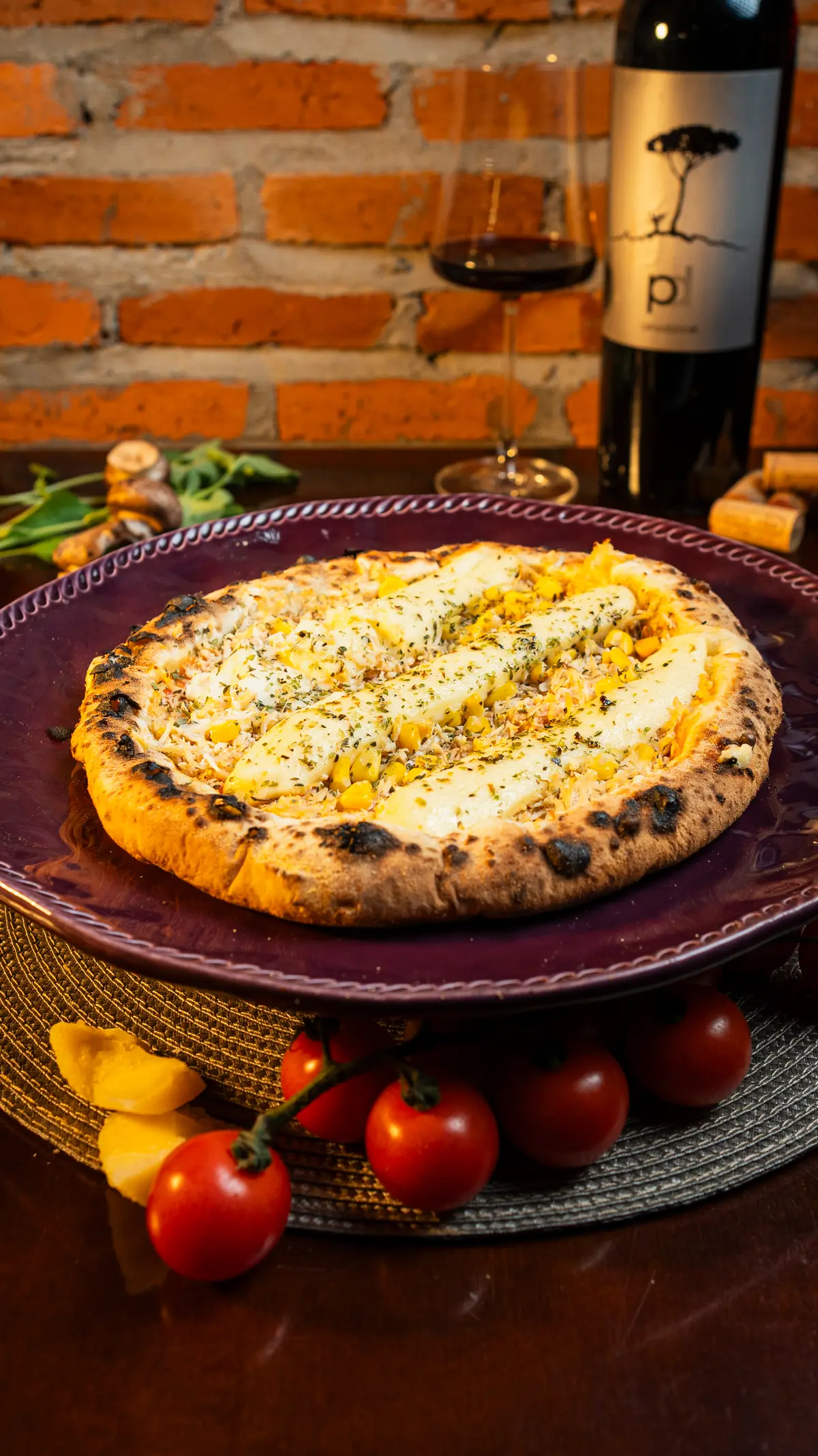 Pizza artesanal da Kahsa da Mamma servida com vinho